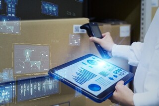 倉庫の荷物をリーダーで読み取り、タブレットで管理する様子